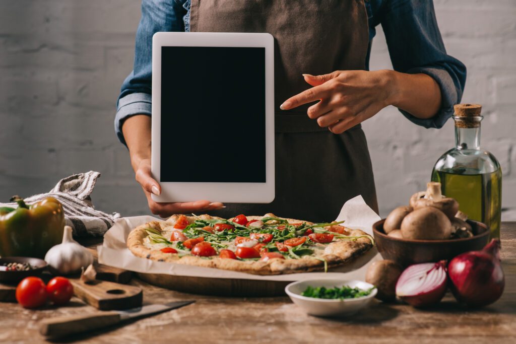 Woamn showing a computer. Pizza online ordering.